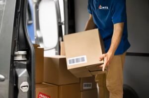 MTS-Courier driver loading next day courier collections into van,