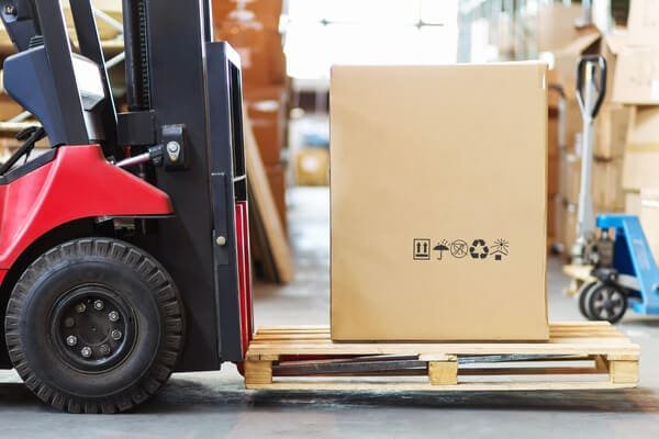 forklift moving a pallet around warehouse getting ready to go out for a delivery